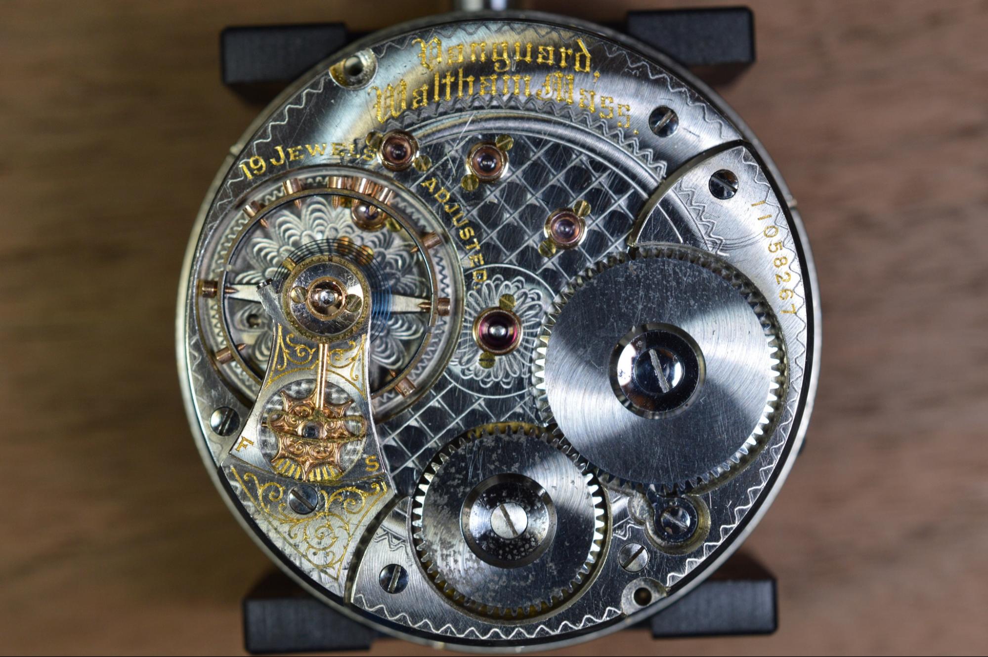 the inside of a watch with the gears and engraving