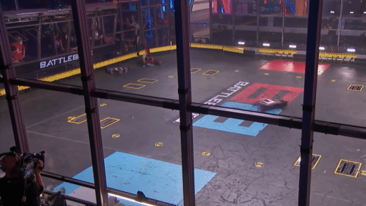 animated GIF of a combat robot knock another robot into the air on the battlebots TV show and a reaction of awe from a judge with pink hair and braides